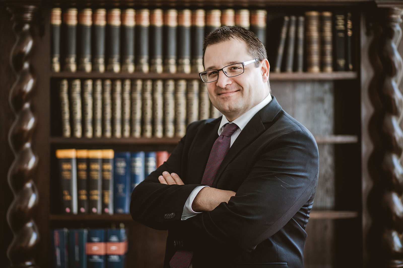 Dr. Friedrich Bamer Portrait vor einer Bücherwand