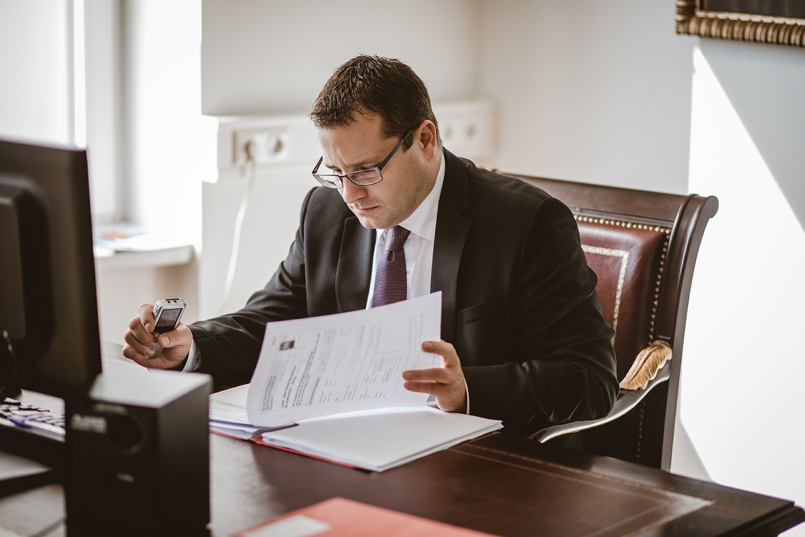 Dr. Friedrich Bamer sitzt am Schreibtisch und sieht Akten durch